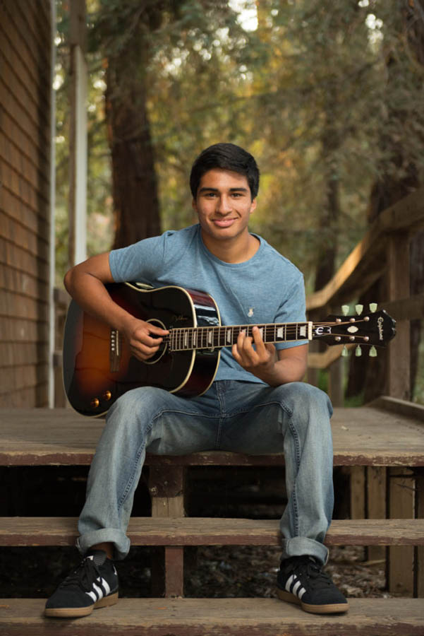 Musically talented High School Senior boy poses with his guitar in Davis CA